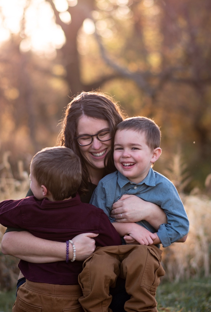Cassie Vitale laughing with two young children in her arms