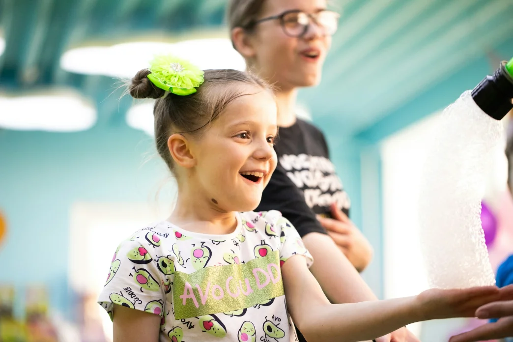 A child smiling during a playful speech therapy activity
