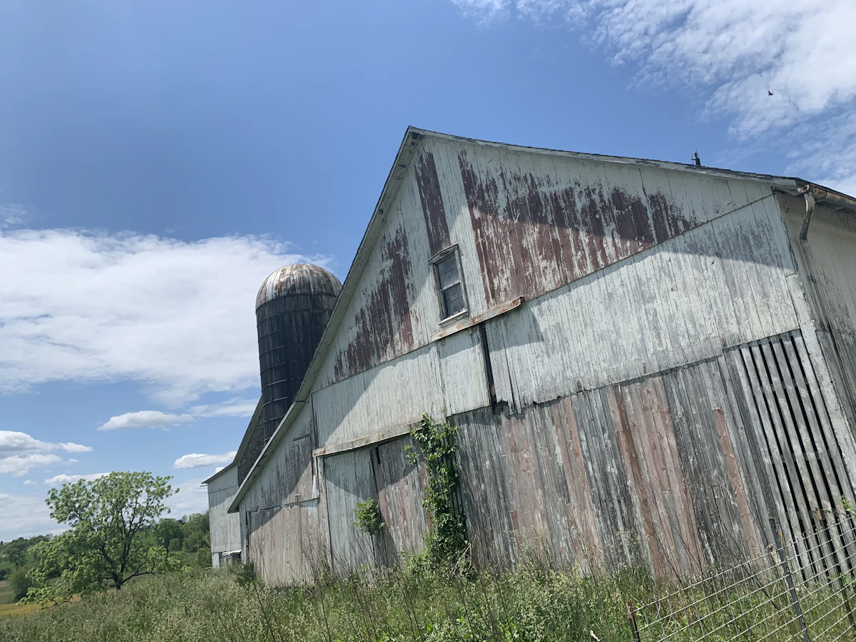 A weathered barn and silo under a blue sky in the Pennsylvania countryside